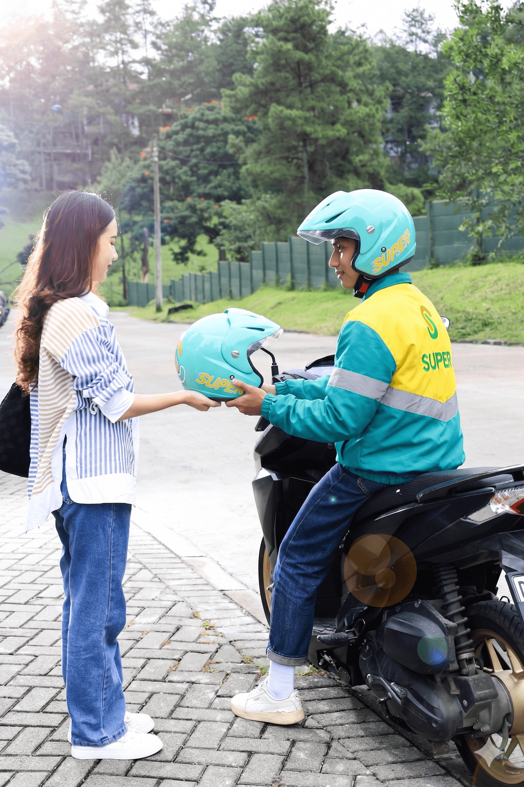 Driver Super Ride menyerahkan helm kepada penumpang sebelum memulai perjalanan